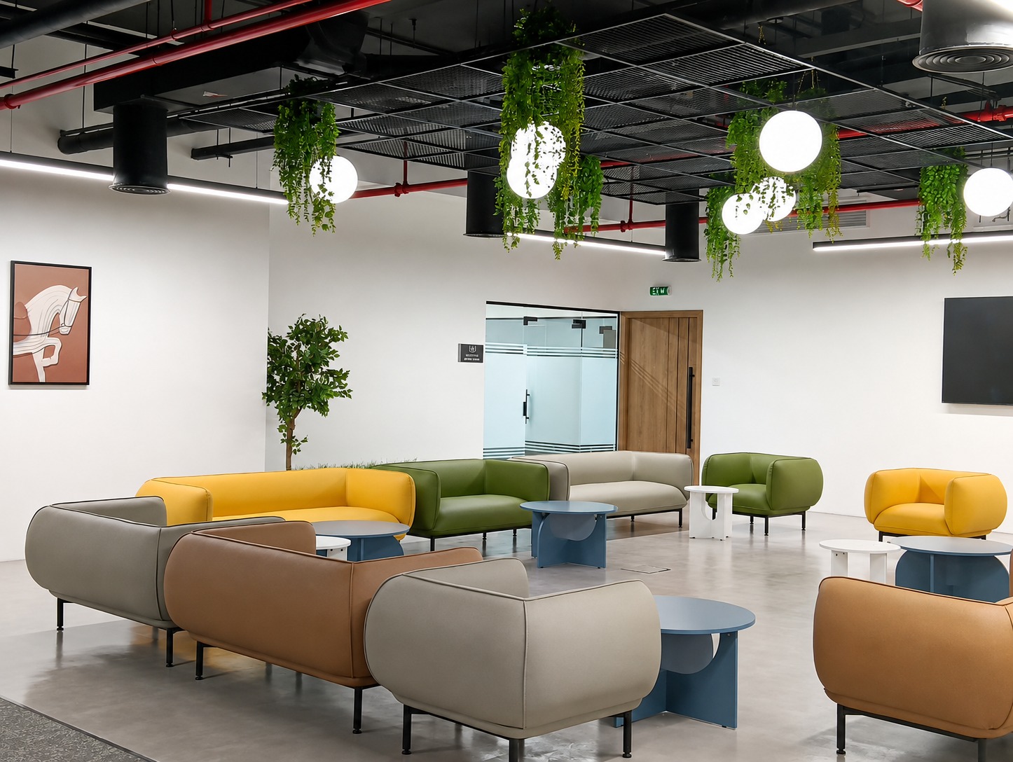 Colourful modern office breakout lounge in Abu Dhabi with mixed-tone sofas, hanging greenery and pendant lighting